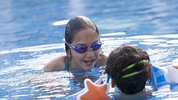 two kids enjoying their swim in the kids pool at South Goa resort with private beach - Caravela Beach Resort, Goa