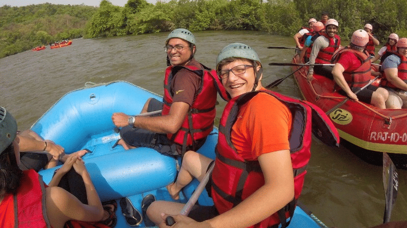 Guests enjoying an exciting river rafting adventure through scenic forest surroundings.