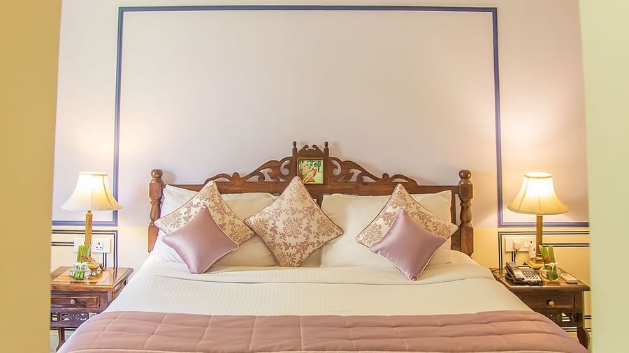 A bedroom at Royal Heritage Haveli with a large bed under a decorative canopy and an arched entrance.