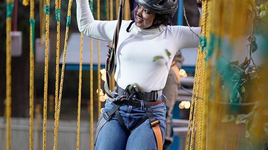 A woman walking on a Rope course at Themis Mudhouse - A Nature's Retreat Resort & Wellness