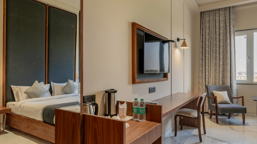 Interior view of a room with a wooden vanity, a large wall-mounted mirror, and a flat-screen television.
