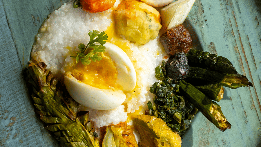 A plated meal featuring white rice, a halved boiled egg, and sautéed greens at Rhino & River Wildlife Retreat & Spa, Pobitora.