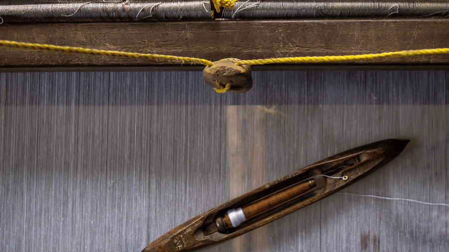 A close-up view of a traditional shuttle resting on a handloom at the Rhino & River Wildlife Retreat & Spa, Pobitora.