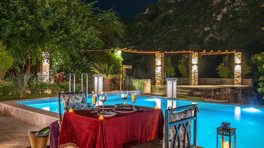 A table with two chairs set beside a swimming pool at Valley by Grassfield.