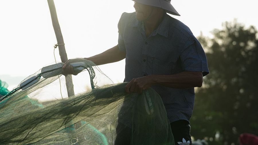 A fisherman reeling in his catch on the beach