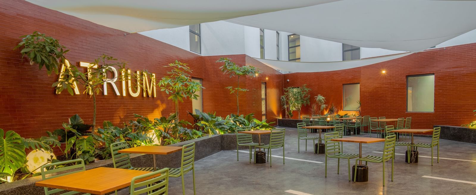 Atrium restaurant at The Pelican Hotel, Accra, featuring shaded seating and a contemporary courtyard vibe.