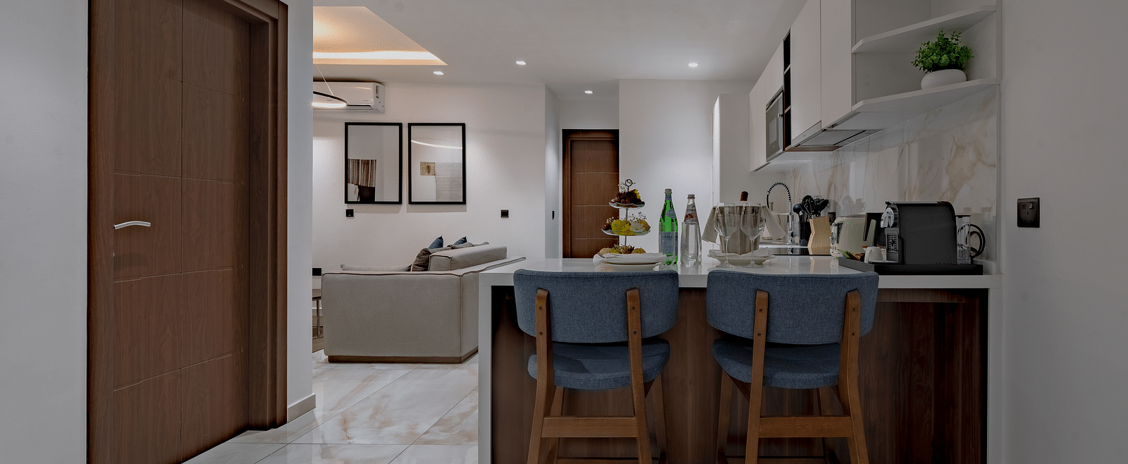 Modern Executive Suite with kitchen island, bar stools, and open floor plan. - The Pelican Hotel, Accra