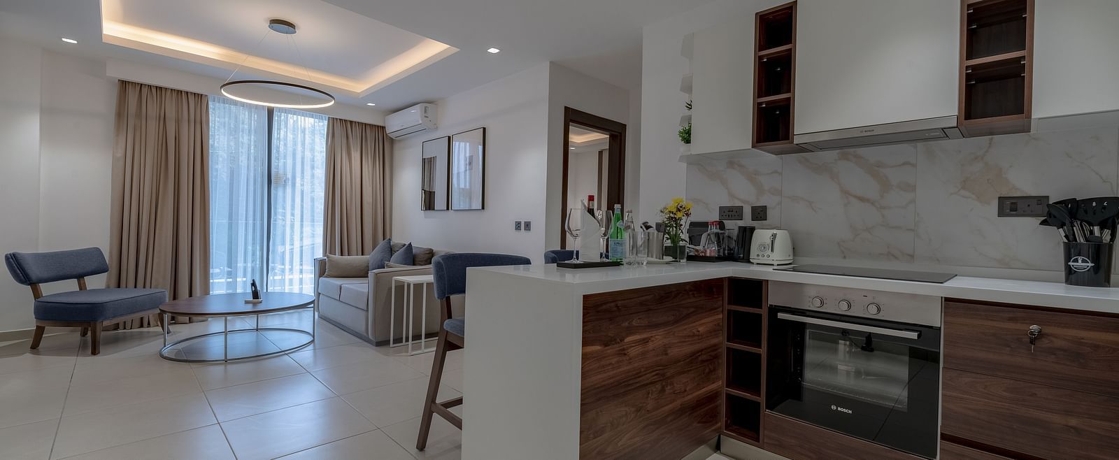 Modern kitchen in a Premier Suite with stainless steel appliances and wood cabinetry. - The Pelican Hotel, Accra