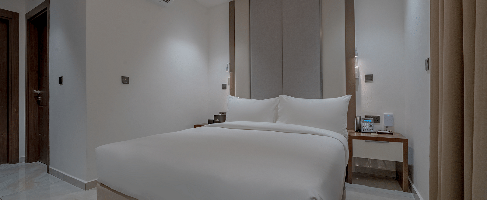Elegant, spacious Deluxe Room with a comfortable bed, bedside tables, and modern decor. - The Pelican Hotel, Accra