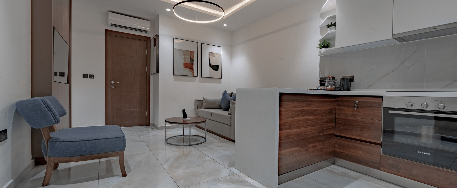 A well-lit Junior Suite with modern kitchen, stylish sofa, and elegant decor. - The Pelican Hotel, Accra