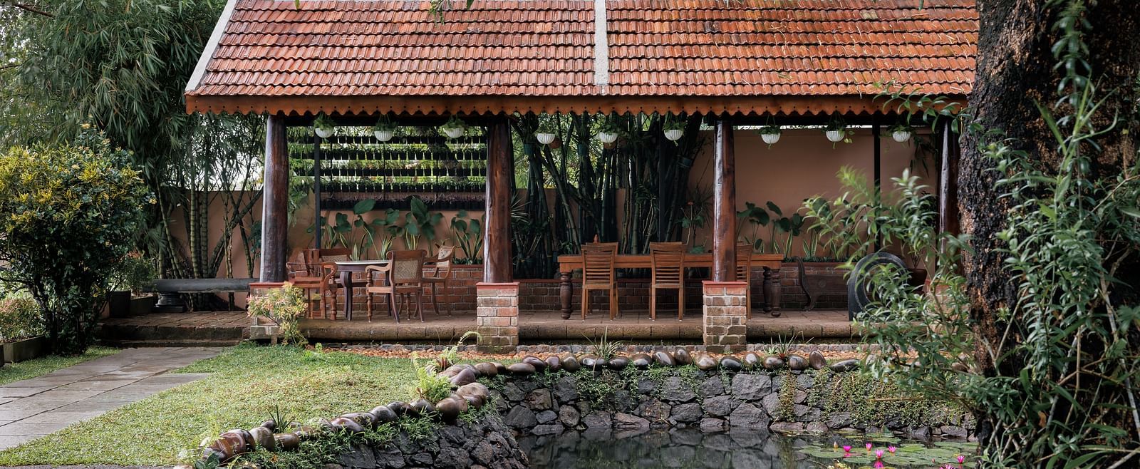 A facade image showcasing the pond at BluSalzz Villas - Muhamma Resort, Alleppey and the outdoor seating area of the restaurant