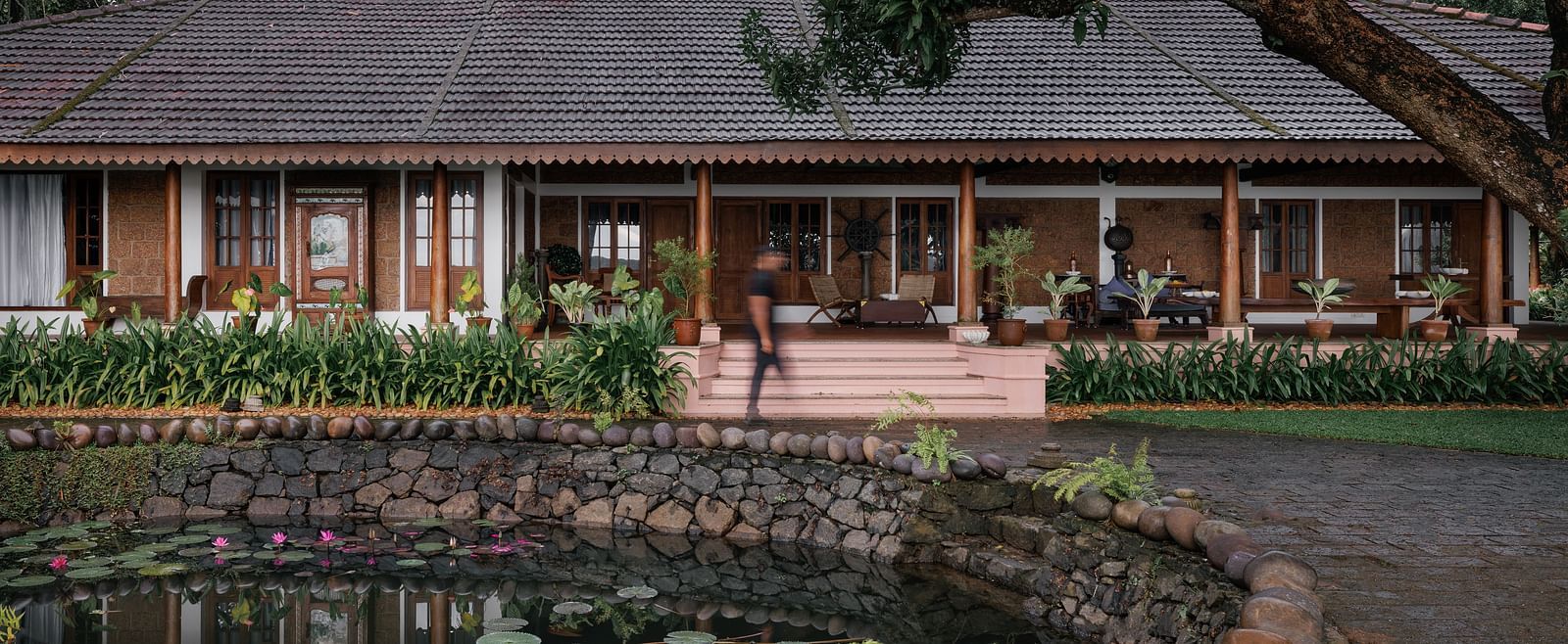 A facade image of BluSalzz Villas - Muhamma Resort, Alleppey with a pond in front of the resort