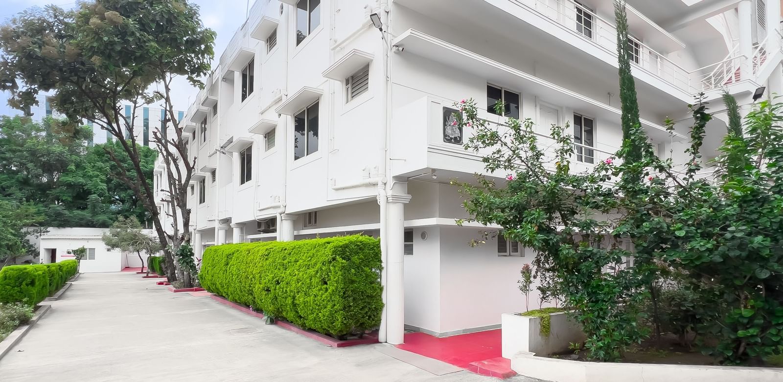 Front view of residential building with pathway and plants at The Pinnacle, Electronic City.