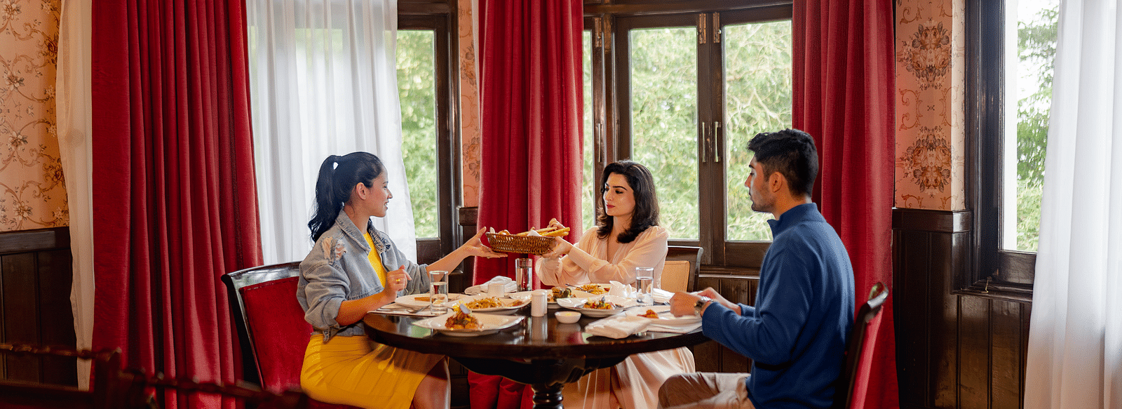Image featuring dining at a beautifully decorated restaurant, seated near large windows that provide an inviting and intimate setting.