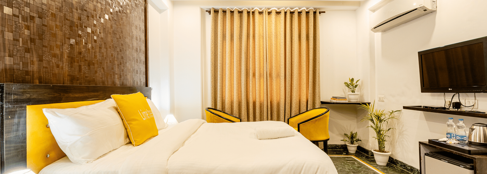 side view of the king size bed with a wall mounted television in the superior double or twin room at Lime Tree Hotels and Banquet Hall Near Huda Metro, Gurgaon