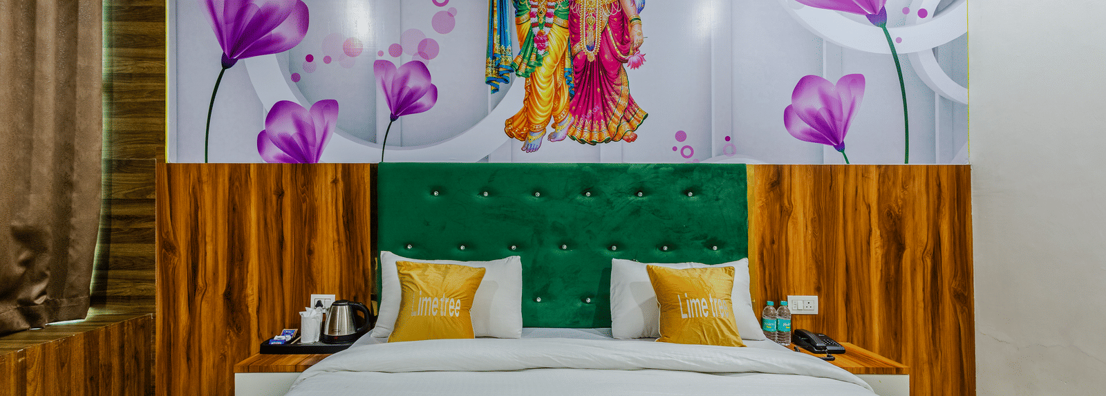 A bedroom with a green headboard, wooden panelling, and floral artwork above the bed - Lime Tree Hotels & Banquet, Vrindavan
