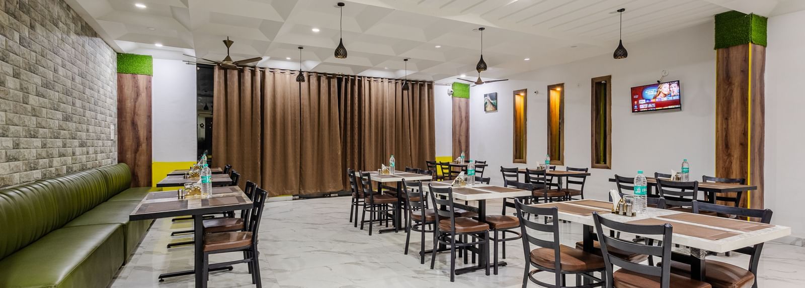 The indoor restaurant at Lime Tree Hotels and Banquet, Vrindavan with well defined seating area.
