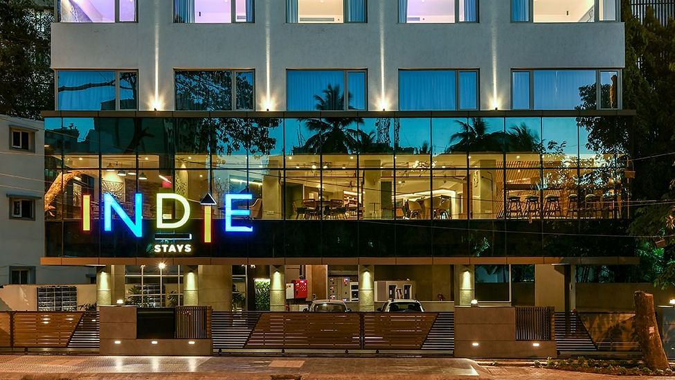 The facade of Indie Stays, BKC, shines against the night sky, with interior lights illuminating the building, creating a highlighted and inviting look