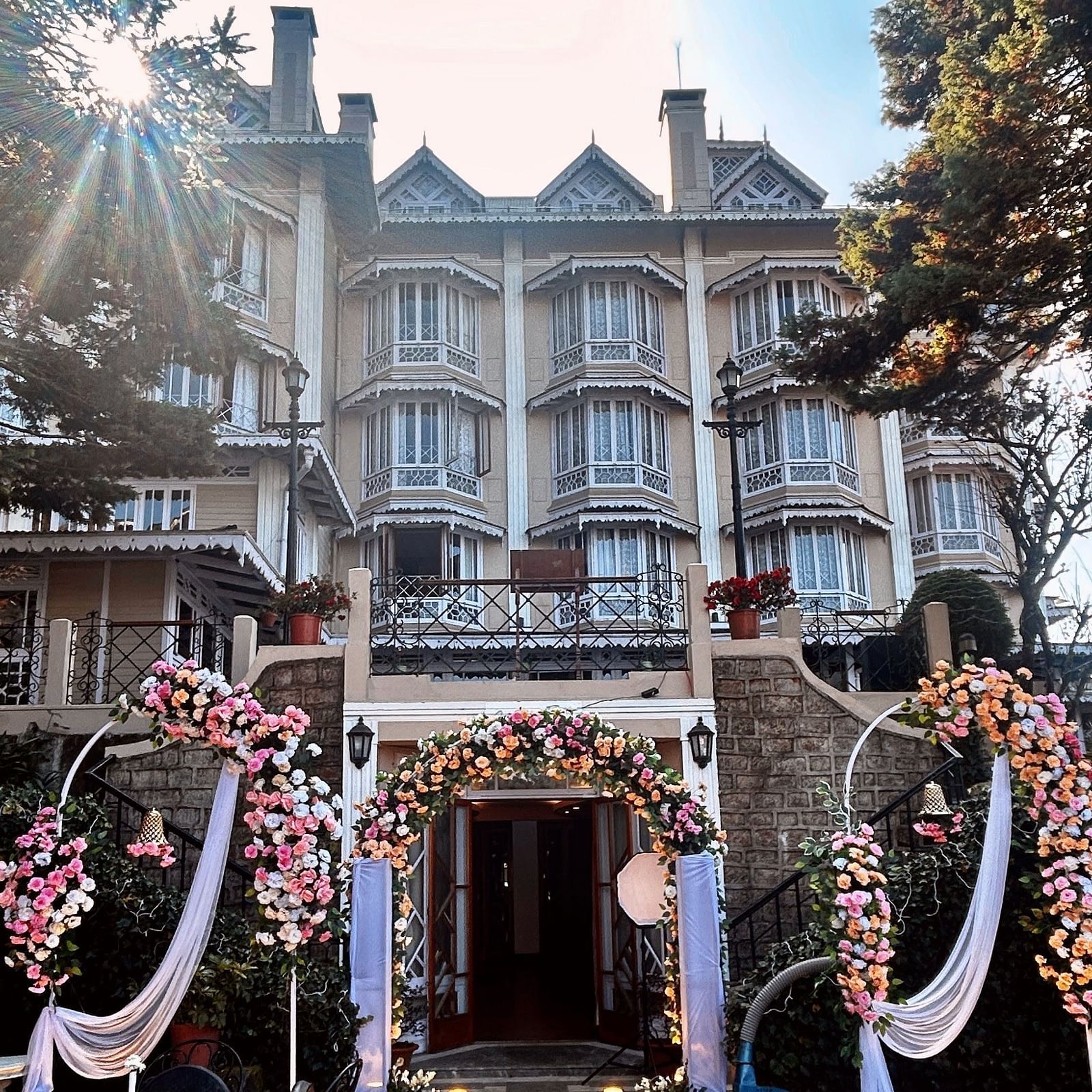 Wedding celebrations at Cedar Inn, Darjeeling, highlighting outdoor seating and traditional decor in front of the hotel façade.