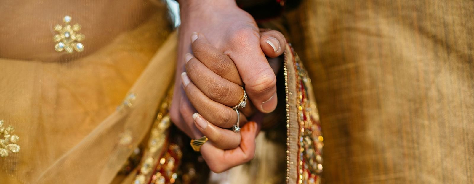Front view of a couple holding hands in traditional attire.