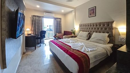 A modern bedroom with a TV, bed, and ambient lighting – The Verda de Miranda Resort.