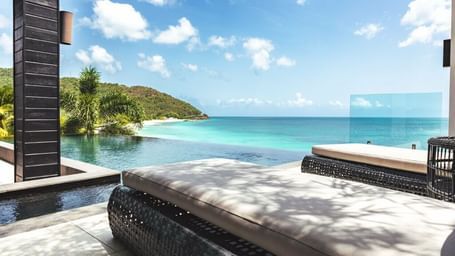 Infinity pool overlooking turquoise waters and green hills at Tamarind Hills Antigua – Resort & Villas