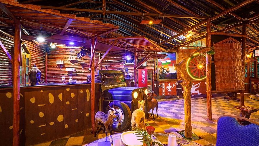 Quirky restaurant interior with vibrant lighting, vintage decor, and a jeep repurposed as a bar counter - Evergreen County