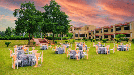 Front Lawn event space at Clarks Khajuraho featuring several sets of tables and chairs in cluster set up.