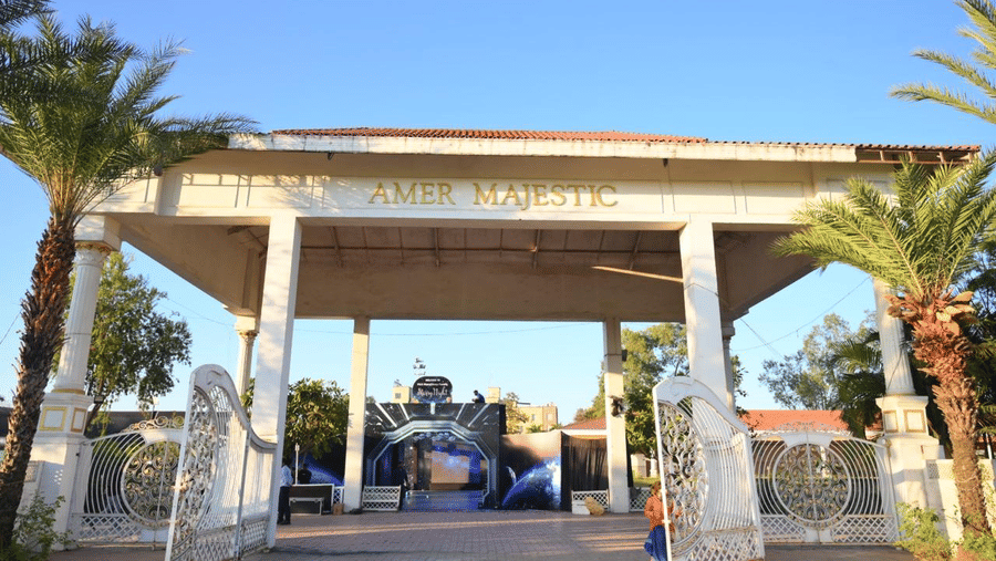 An entrance gateway with pillars, an open driveway, and event signage placed near the walkway.