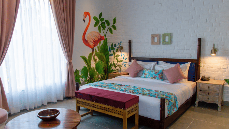 A king bed at The Sierra Udaipur featuring a futon at the base inside the Elite Room.