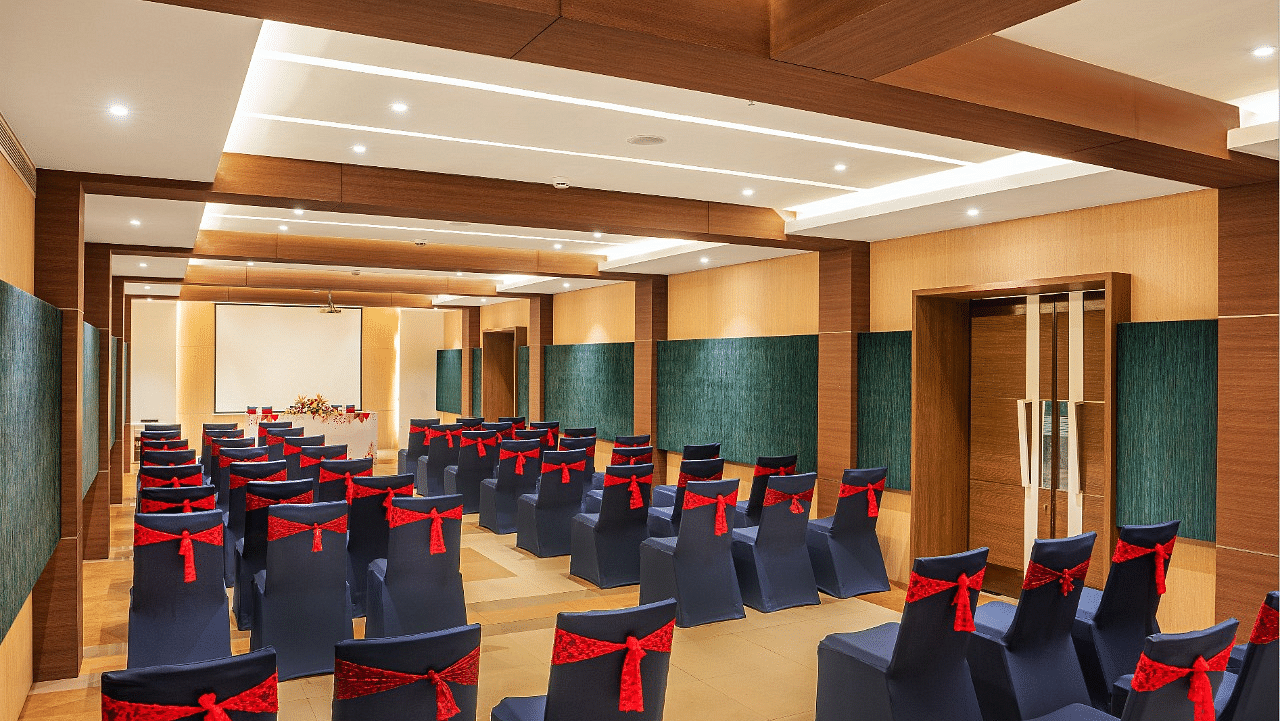 An image of huge wooden ceiling  hall with well arranged chairs at Grand Kakinada by GRT Hotels