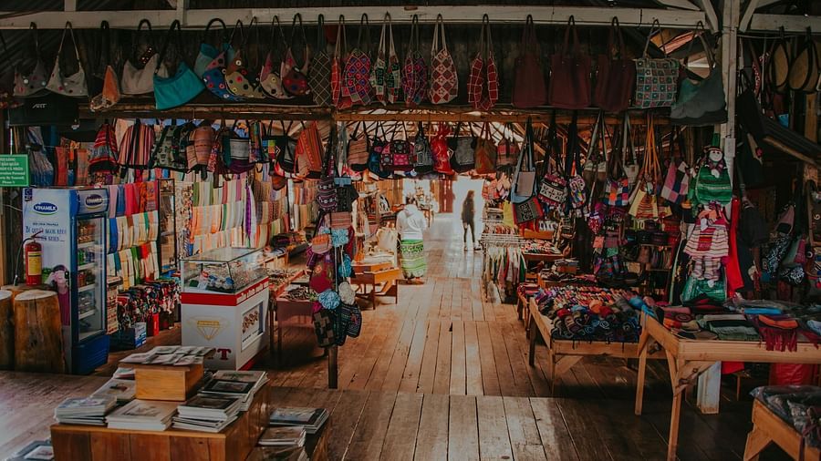 Image of  a market with wooden floors and items hanging from the ceiling.