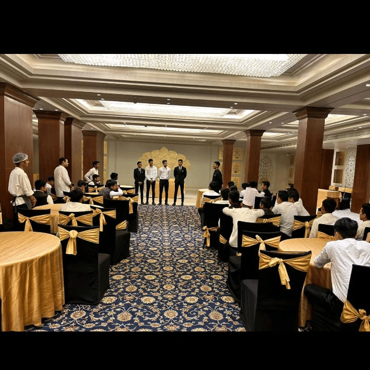 An overview of a hall filled with tables and chairs during a function at Clarks Group of Hotels. Guests sit around the room.