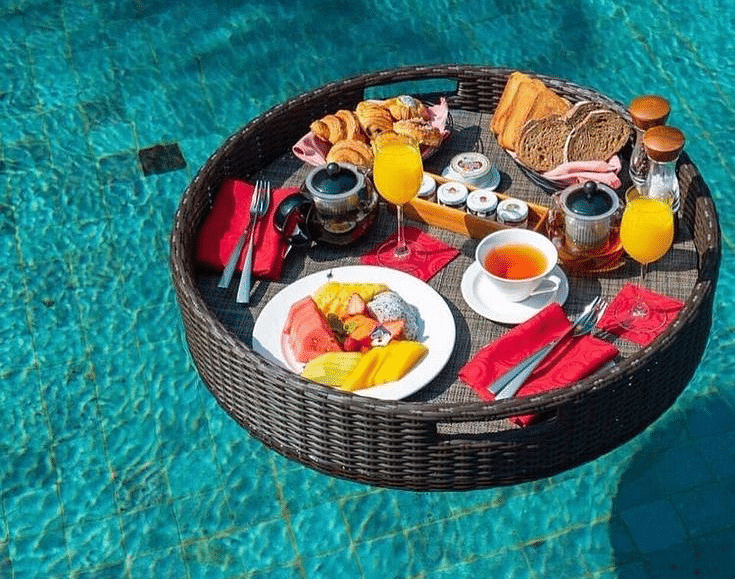A tray floating on a water body with a variety of food placed on it at Valley by Grassfield.