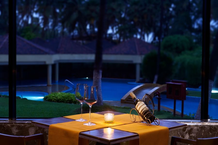 A view of a dining table set next to the pool for a candlelight dinner at The Retreat Hotel and Convention Centre