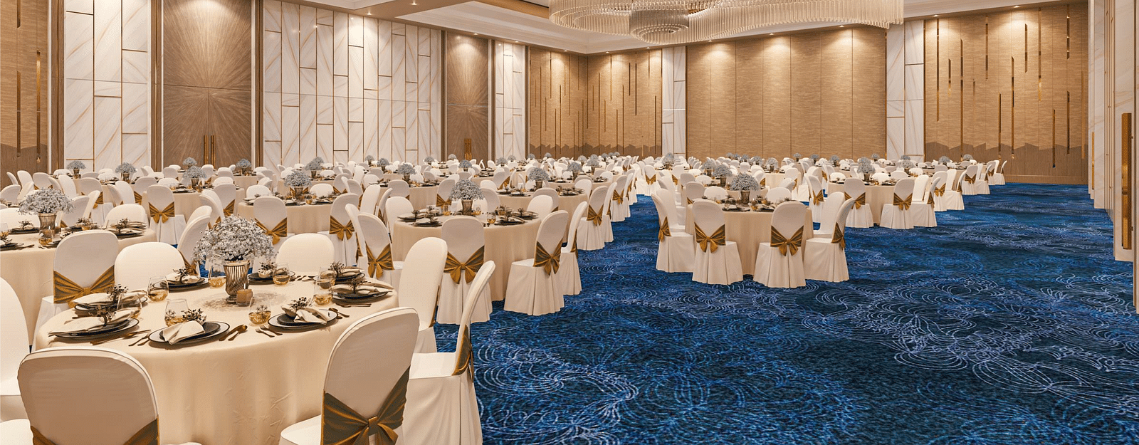 A banquet seating arrangement with chandeliers, blue carpet and modern interior at Merlis Hotel, Coimbatore