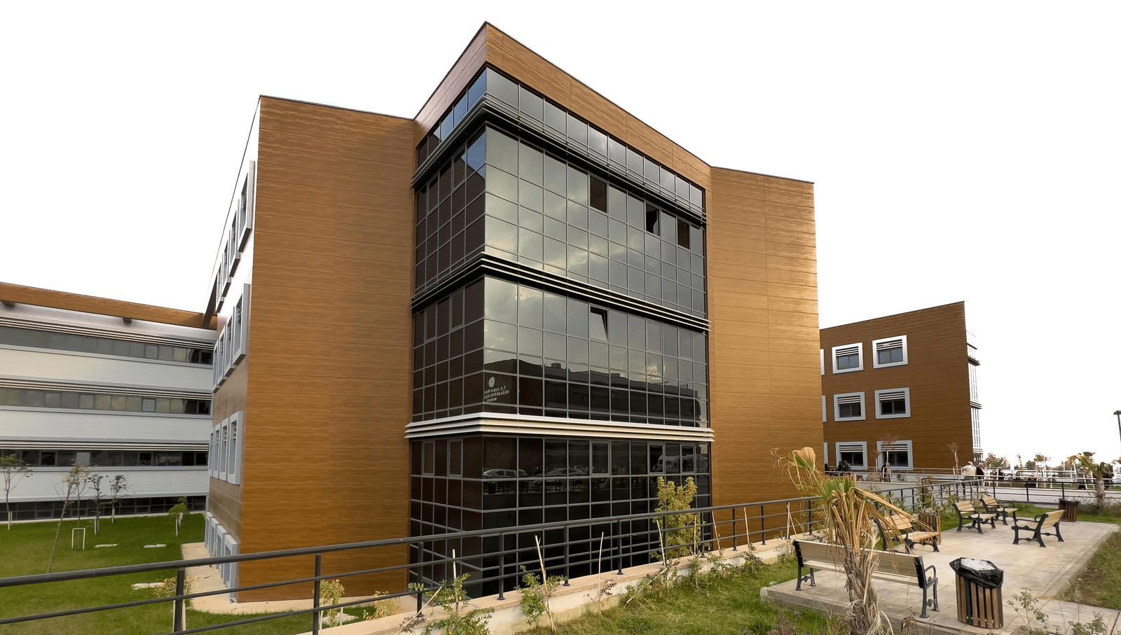 An image of a building surrounded by lawns where benches are placed