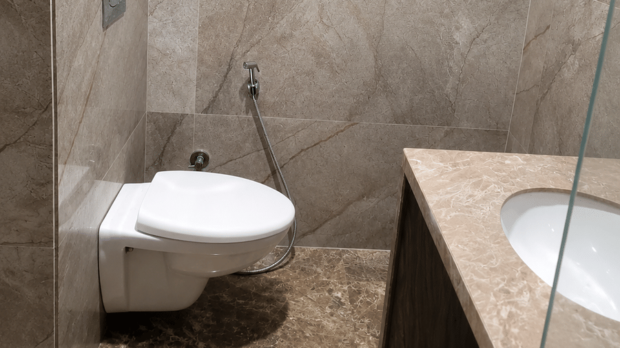 Modern bathroom with toilet, washbasin and tiled walls at Bamboo Saa Mulberry Resort, Pushkar.