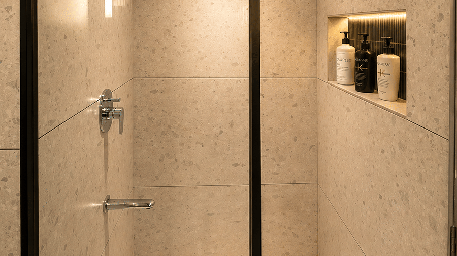 A bathroom with showerhead, taps, and other toileteries. | The Oriental Residency