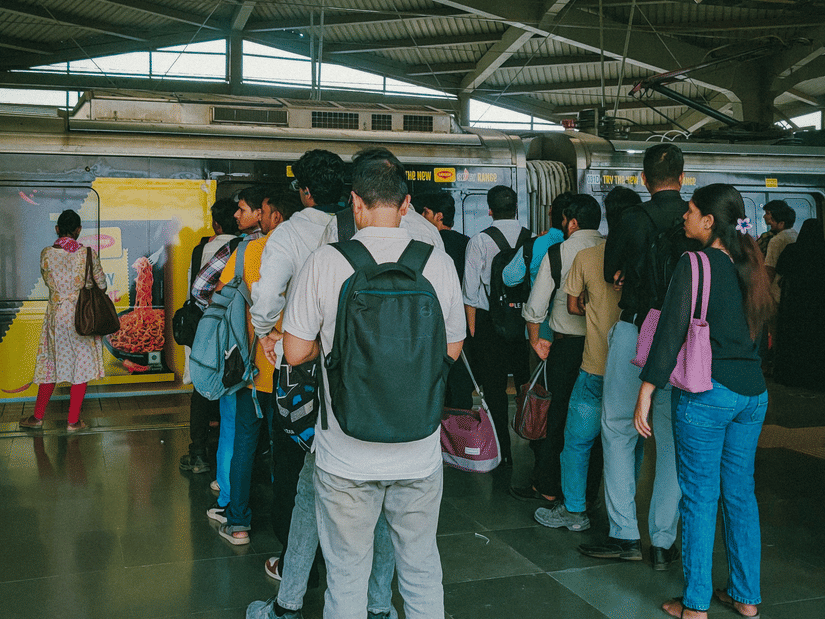 Daily commuters waiting to board a suburban train at a busy railway station during peak travel hours