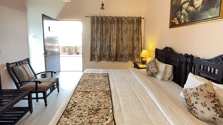 Side view of the Double bed at Deluxe Double with a view of the main door at Suryaa Villa Jaipur
