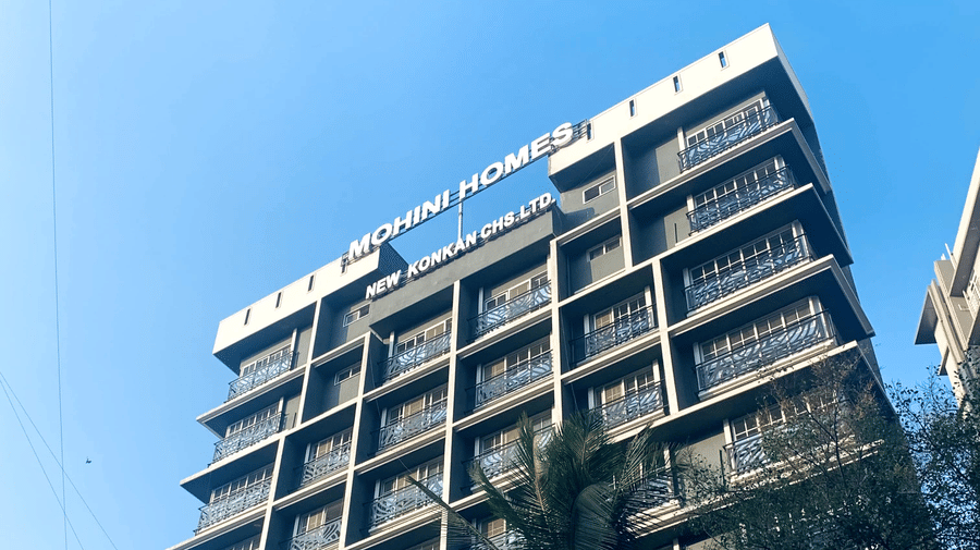 Low-angle view of the multi-storey Home2 Residency, Mumbai Airport, building facade against a bright blue sky.