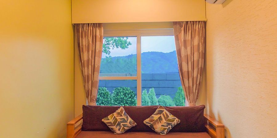 Window behind a sofa and coffee table in Living Room - Garden Suite- The Golden tusk