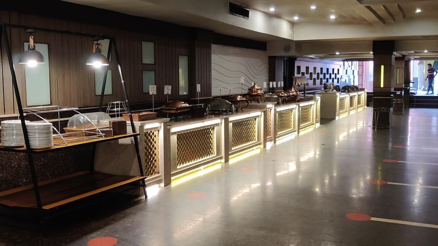 The buffet counter with illuminated platform counters and a cutlery station at the Banquet Hall at Hotel Gold, Panipat.