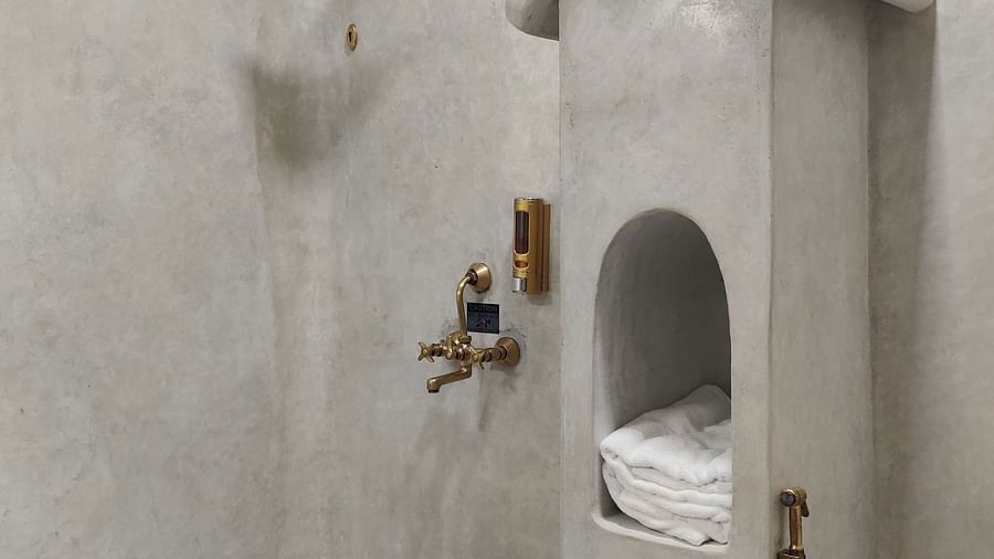 Albacore-5 - washroom with white-grey themed walls amd copper taps, shower heads giving off a premium feel.