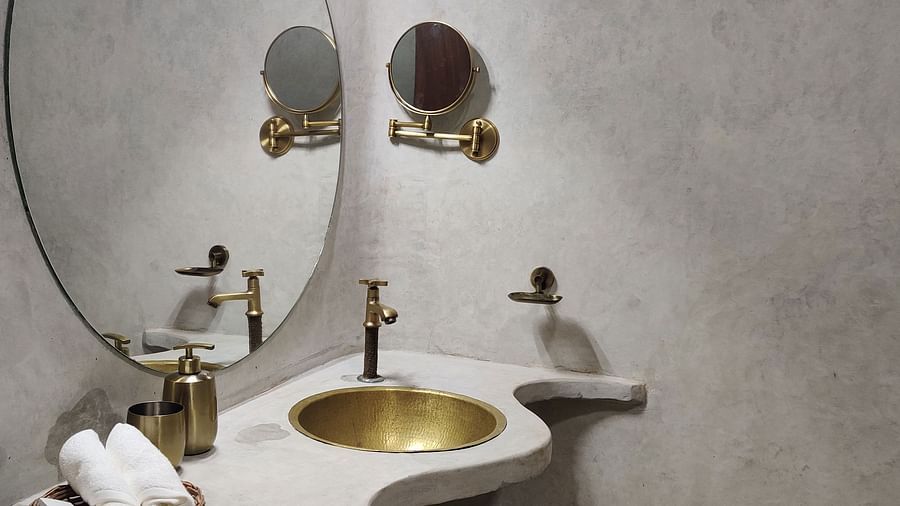Albacore-6-washroom with a well lit mirror and a golden wash basin fully equipped with towels and other neccesities.