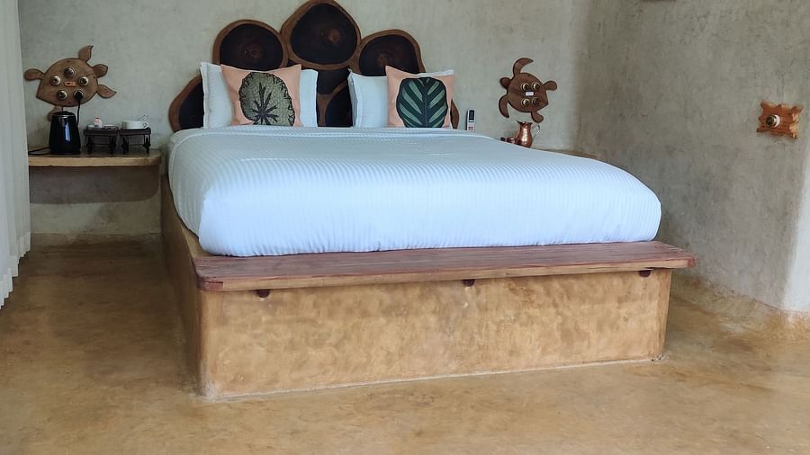 Amberjack-plush bed with a wooden frame and matching floor tiles, with white linens.