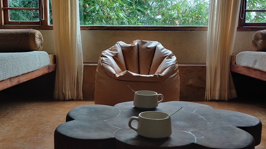 Living room with a tea table and a window with outside vistas, and bean bags placed for ultimate relaxation.