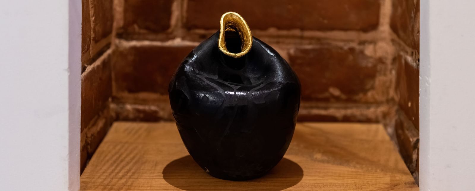 A vase made of brass which is placed on a table at the Nepali Suite - The Nanee