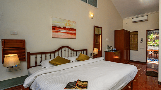 A double bed with a book on it lamps on the side inside Cassis room in Neemrana s Three Waters